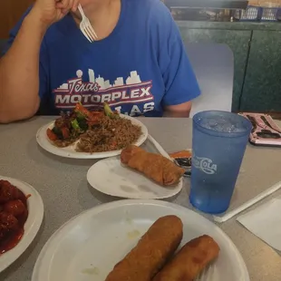 a woman sitting at a table with plates of food