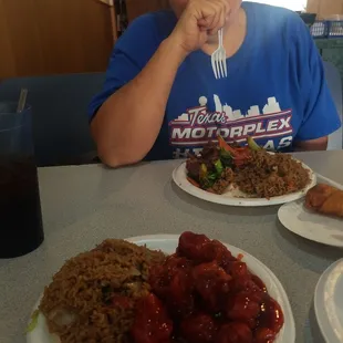 a woman sitting at a table with plates of food