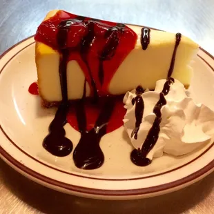 a piece of cheesecake with whipped cream and strawberries