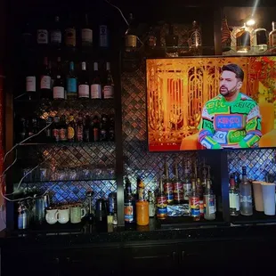 a man in a green shirt behind a bar