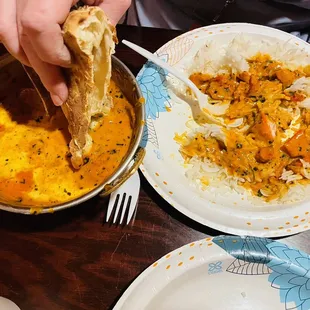 a person dipping a piece of bread