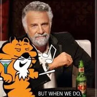 a picture of a man sitting at a table with a drink and a cat