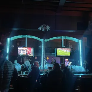 people sitting at the bar watching the game