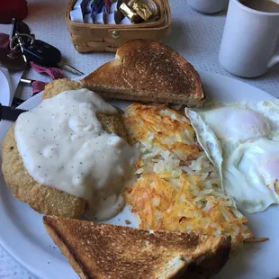 a breakfast plate with eggs, toast, and hash browns