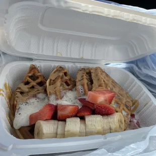 Protein Waffles drizzled with syrup &amp; peanut butter along with strawberries &amp; bananas