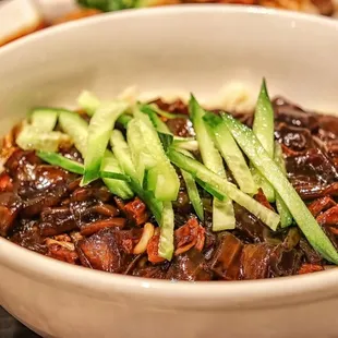 a bowl of noodles with meat and vegetables