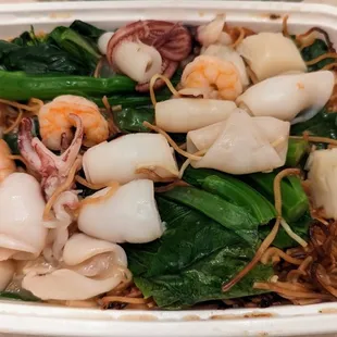 a container of seafood and noodles