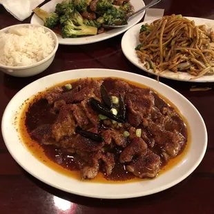 a plate of beef with noodles and broccoli