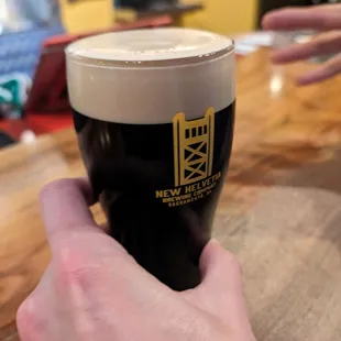 a hand holding a pint of beer