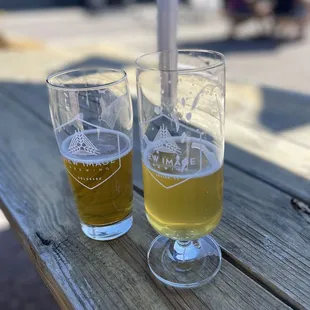 two glasses of beer on a picnic table