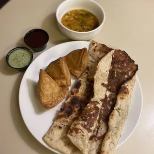 Garlic Naan, 3 Vegetable Samosas, Dal Soup(Bean Soup), Green Chutney (Sauce), Tamarind Sauce.