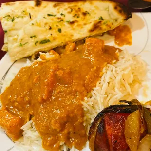 Chicken Tikka Masala, jasmine rice and garlic naan bread with a chicken leg from tandoori chicken dish