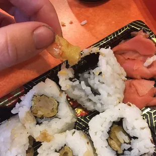 a person dipping a piece of sushi