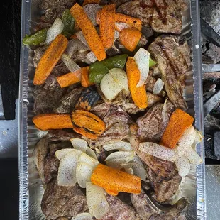 lamb chops with rice in the bottom and grilled veggies