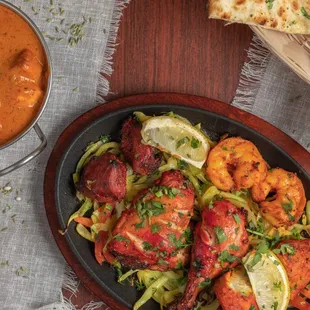 a pan of chicken tikka masala with a side of naan bread