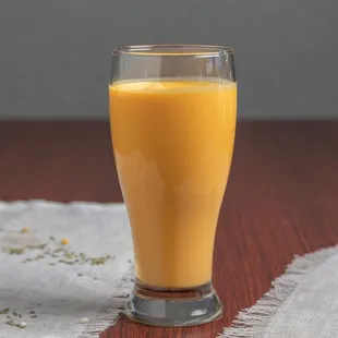 a glass of orange juice on a table