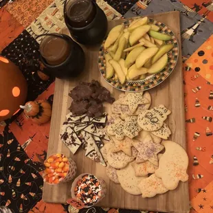 a wooden cutting board with a variety of snacks