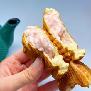 a hand holding a half eaten pastry