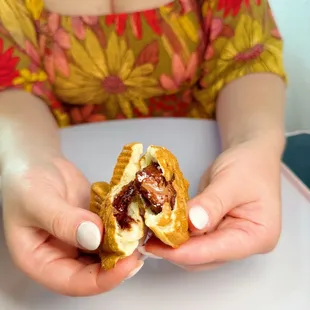 a woman holding a half eaten pastry