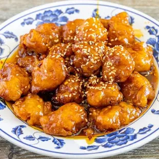 a plate of chicken with sesame seeds