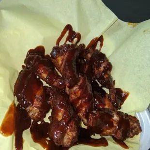 a plate of chicken wings covered in bbq sauce