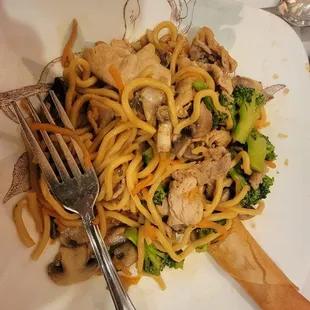 a plate of noodles with mushrooms and broccoli