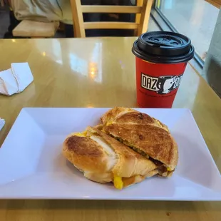 Bacon egg &amp; cheese croissant with a cup of hot coffee