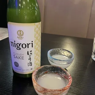 a bottle of nigori and a small bowl of yogurt