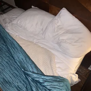 Unchanged bed with hair and stains under the covers.