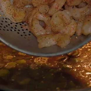 Adding shrimp to delicious Creole Gumbo!