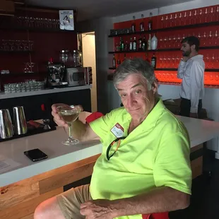 a man sitting at a bar with a glass of wine