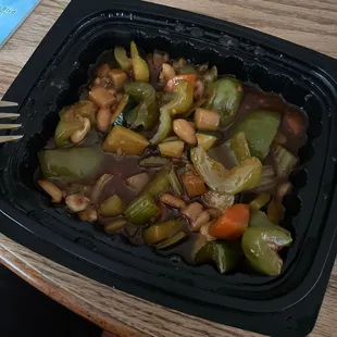 a bowl of vegetables and a fork on a table
