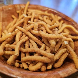a wooden bowl full of crispy fries