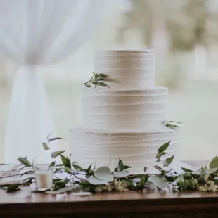 a white wedding cake with greenery