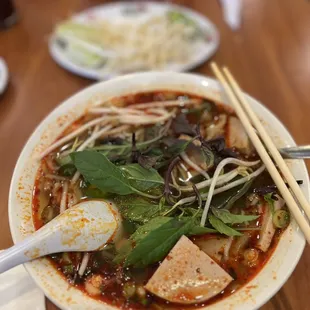 a bowl of soup with chopsticks