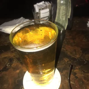 a glass of beer on a coaster