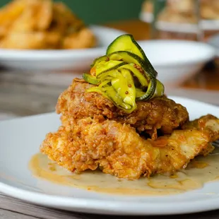 fried chicken with a pickle on top