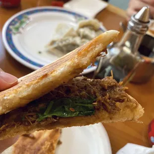 a hand holding a sandwich