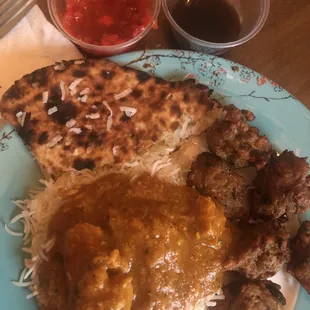 Delicious curry, onion bahji with dipping sauces, coconut stuffed naan, rice.