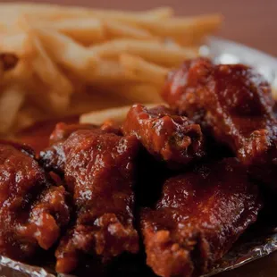 a plate of chicken wings and french fries