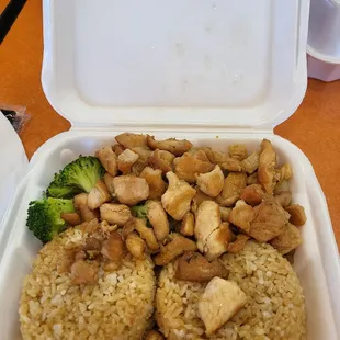 a container of rice with chicken and broccoli