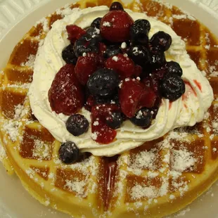a waffle with whipped cream and berries