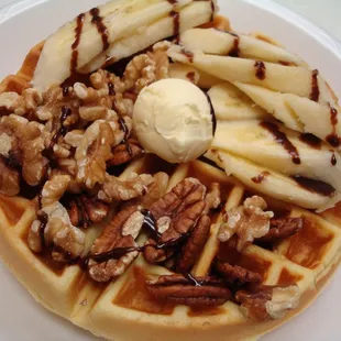 a waffle with bananas, walnuts, and ice cream