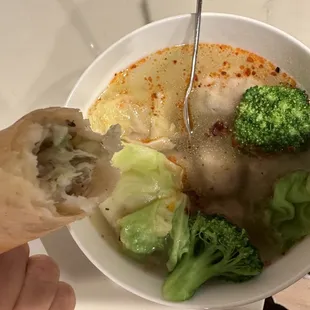 Close-up of wonton soup and egg roll