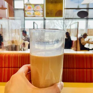 a person holding a glass of coffee