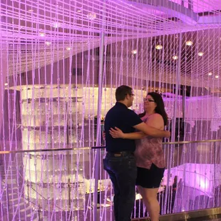 a man and a woman embracing in a purple room