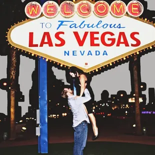 a man standing in front of a welcome sign