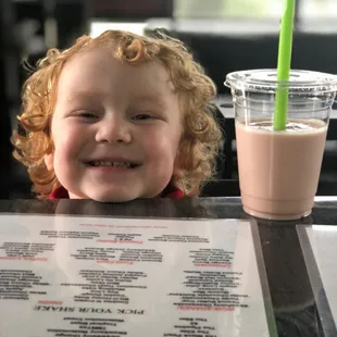 a child smiling at a menu