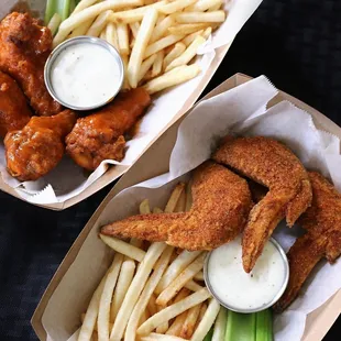 two baskets of chicken wings and french fries