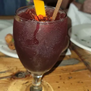 a glass of wine with a cinnamon stick sticking out of it